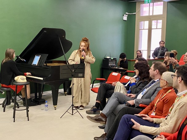 Uma pianista e uma cantora se apresentam para a plateia no auditrio Luis Cosme