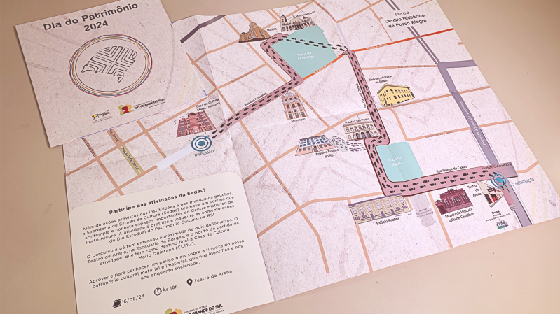 Foto do passaporte do Dia do Patrimônio que mostra o mapa estilizado do centro de Porto Alegre com a localização de instituições culturais participantes do evento e trajeto do Cortejo de abertura. 