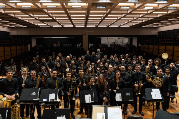 Os integrantes da Ospa Jovem estão em pé, sobre o palco