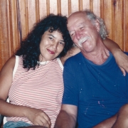 Na imagem, Aurora, esposa de Jayme Caetano Braun, uma mulher de cabelos cacheados, vestindo uma blusa branca e vermelha listrada, com o braço em volta de Jayme Caetano Braun, um homem branco, de cabelos curtos, vestindo uma blusa azul.
