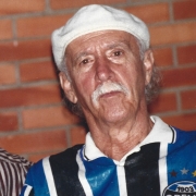 Na imagem, ao lado esquerdo, Lucio Yanel, um homem negro, de cabelos curtos, vestindo uma camiseta listrada. Em seu lado direito, Jayme Caetano Braun, um homem branco, de cabelos curtos, vestindo boina e uma camiseta do clube de futebol grêmio, na cor azul.
