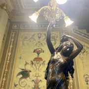 Imagem de pintura mural da BPE e, à frente, um lustre