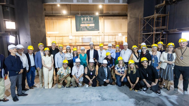 Diversas pessoas em pé, olhando para a câmera, na obra do Teatro Italiano