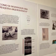 A imagem mostra um painel explicativo sobre a pesquisa arqueológica no Estado do RS. 