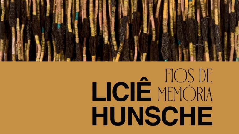 A imagem é uma parte da capa do catálogo da exposição “Liciê Hunsche – Fios de memória”. Ao fundo, há diversos fios pendurados, de cores variadas. À frente, há uma tarja em amarelo queimado, sobre a qual há os textos "Liciê Hunsche" e "Fios de Memória"