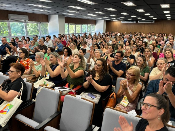 Em um auditório lotado, o público bate palmas