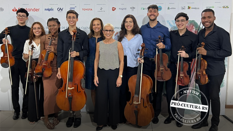 Secretária Beatriz Araujo ao lado de jovens músicos