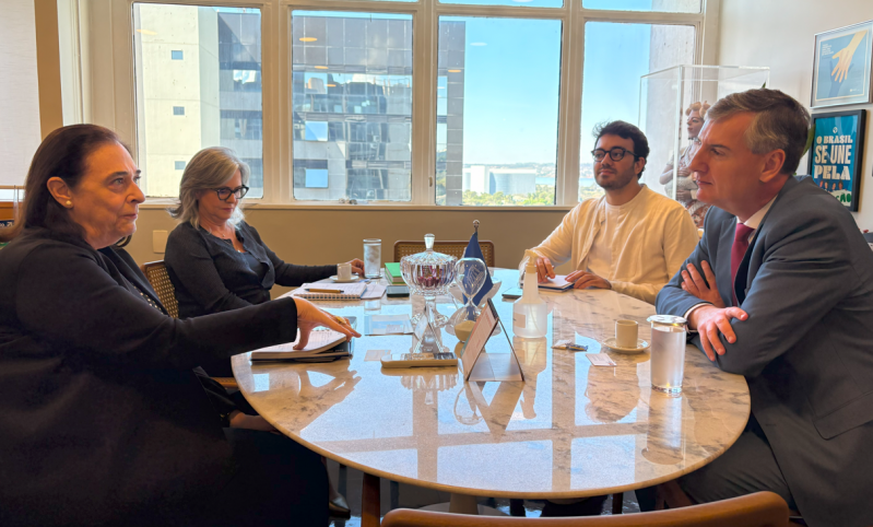 Reunião em uma sala com janelas grandes e vista para edifícios. Sentados à mesa estão o secretário de Cultura Eduardo Loureiro, junto da diretora da Unesco Marlova Noleto e da coordenadora de Cultura, Isabel de Paula