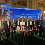 Em um palco, o Governador Eduardo Leite segura um documento ao lado do vice-governador Gabriel Souza, e dos Secretários Eduardo Loureiro, da Cultura, e Ronaldo Santini, do Turismo.