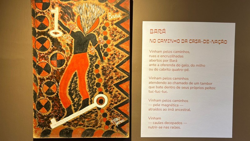 Fotografia de uma parte da exposi&ccedil;&atilde;o "Orix&aacute;s &ndash; Pintura e Poesia". &Agrave; esquerda, h&aacute; uma pintura assinada por Pedro Romero que representa a figura da divindade Bar&aacute;. A figura tem cal&ccedil;as vermelhas largas, tronco preto e cabelos em chamas ou raios claros. Ao redor, o fundo &eacute; preenchido por padr&otilde;es geom&eacute;tricos circulares e triangulares nas cores preto, vermelho e bege. Duas chaves brancas aparecem como elementos centrais da obra, uma acima e outra abaixo da figura.

&Agrave; direita da pintura, h&aacute; uma poesia de Oliveira Silveira, exposta em painel branco com t&iacute;tulo em laranja que diz:

BAR&Aacute; &mdash; NO CAMINHO DA CASA-DE-NA&Ccedil;&Atilde;O

Segue o poema:

&ldquo;Vinham pelos caminhos,
ruas e encruzilhadas
abertos por Bar&aacute;
ante a oferenda do galo, do milho
ou do cabrito quatro-p&eacute;.

Vinham pelos caminhos
atendendo ao chamado de um tambor
que bate dentro de seus pr&oacute;prios peitos:
tuc-tuc-tuc.

Vinham pelos caminhos
&mdash; pele magn&eacute;tica &mdash;
atra&iacute;dos ao &iacute;m&atilde; ancestral.

Vinham
&mdash; caules decapitados &mdash;
nutrir-se nas ra&iacute;zes.&rdquo;