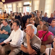 Imagem mostra plateia sentada em evento. 