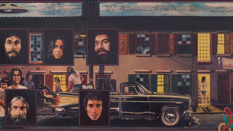 A imagem mostra uma ilustra&ccedil;&atilde;o/arte pintada com estilo retr&ocirc;, lembrando capas de discos ou p&ocirc;steres dos anos 60&ndash;70. A cena mostra uma rua residencial &agrave; noite, com casas geminadas ao fundo, feitas de tijolos e com janelas iluminadas. Na frente das casas h&aacute; um carro cl&aacute;ssico preto, estacionado na rua. Ao redor do carro aparecem v&aacute;rias pessoas conversando ou caminhando, como se fosse um encontro entre amigos ou vizinhos. Sobre a cena principal foram colocados cinco retratos de homens, em molduras quadradas. Esses rostos parecem fotografias recortadas e colocadas sobre a ilustra&ccedil;&atilde;o. Os homens t&ecirc;m apar&ecirc;ncia de adultos com barba ou cabelo longo, lembrando m&uacute;sicos ou integrantes de uma banda. &Agrave; direita da imagem h&aacute; uma mulher em p&eacute; perto da porta de uma casa iluminada. A ilumina&ccedil;&atilde;o das janelas cria um contraste entre a noite na rua e a luz quente dentro das casas. A composi&ccedil;&atilde;o mistura arte ilustrada com retratos reais, dando a impress&atilde;o de um p&ocirc;ster ou capa de &aacute;lbum.