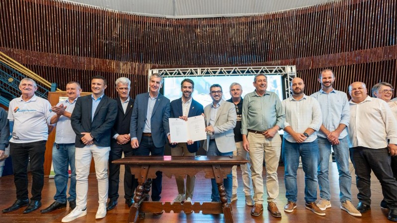 Diversos prefeitos sorriem para foto. No centro do grupo, o secret&aacute;rio da Cultura, Eduardo Loureiro, o governador Eduardo Leite e o presidente da AMM, Jo&atilde;o Alberto Aquino exibem um documento.  