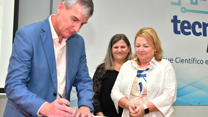 O Secret&aacute;rio da Cultura, Eduardo Loureiro, assina um documento ao lado de duas mulheres: professora Berenice Beatriz Rossner Wbatuba (no centro) e Maria Cristina Bohn Martins (&agrave; direita).   