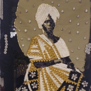 Obra têxtil em tons de preto, dourado e bege representa uma pessoa sentada usando um vestido elaborado, composto por rendas, bordados, lantejoulas, botões e conchas. A figura ocupa o centro da imagem e aparece diante de um fundo bege pontuado por pequenas conchas distribuídas regularmente. O traje apresenta padrões geométricos e florais detalhados, com faixas douradas e painéis escuros decorados por flores formadas por conchas. A combinação de materiais cria relevo e textura, dando à composição a aparência de um mosaico artesanal construído com elementos têxteis e naturais.